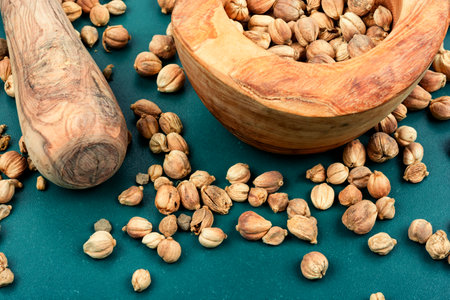 White dried cardamom or kapulaga in a wooden bowl. Dried herb spice.