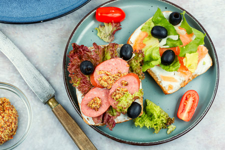 Sandwiches with salted salmon, and sausages. Grain bread, with cream cheese fish and salami, black olives and greens. Breakfastの写真素材
