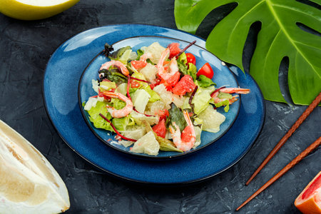 Diet salad with pomelo, shrimps and greens on a dark background. Healthy eating.の写真素材