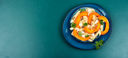 Pasta with baked pumpkins and nuts. Tasty autumn food. Space for text.の写真素材