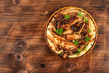 Piece of open mushroom pie, mushroom galette. Tart or pie with mushrooms on a wooden table. Copy...