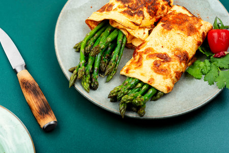 Omelet cooked with green asparagus and fresh herbsの写真素材