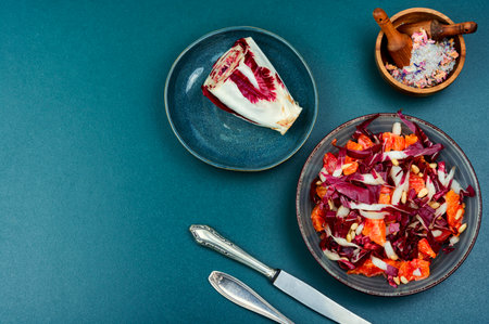 A bowl of fresh salad with red chicory or red radicchio and orange. Copy space.の写真素材