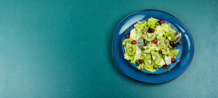 Salad of kiwi, lettuce, berries and pine nuts. Keto diet. Copy space