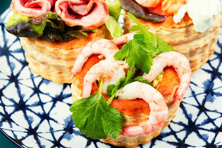 Appetizing tartlets with fish, shrimp and bacon. Festive table.の写真素材