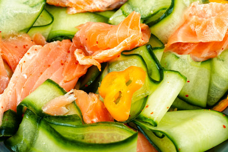 Fresh spring salad with smoked salmon fillet and fresh cucumber. Close up.の写真素材