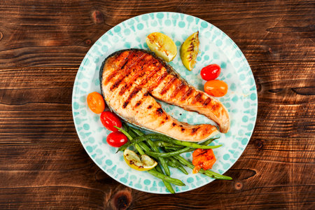 Grilled salmon steak with grilled vegetables, fried fish.の写真素材