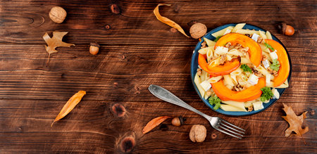 Seasonal autumn dish, pasta with baked pumpkins and nuts. Space for text.の写真素材