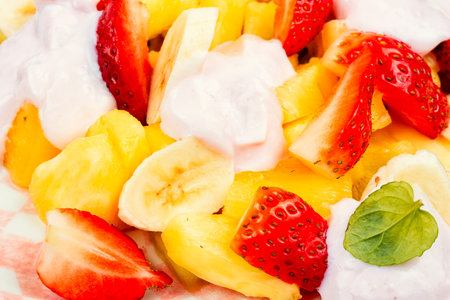 Fruit salad of pineapple, strawberries, kiwi and sweet yogurt. Healthy natural organic food. Macro.の写真素材