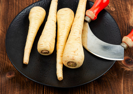 Raw parsnip roots on the kitchen table. Root vegetables. Homeopathic herbs.の写真素材