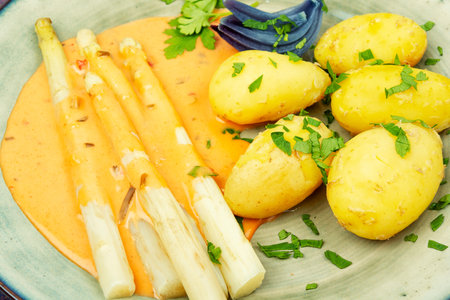 Boiled white asparagus with hollandaise sauce with new potatoes, vegetarian.の写真素材