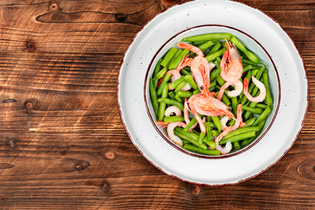 Delicious salad with shrimp and green beans on rustic wooden table. Healthy green salad. Copy space.の写真素材