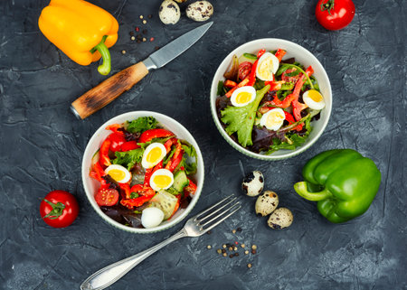 Diet salad of fresh vegetables and quail eggs on a concrete background.. Healthy food. Top view.の写真素材