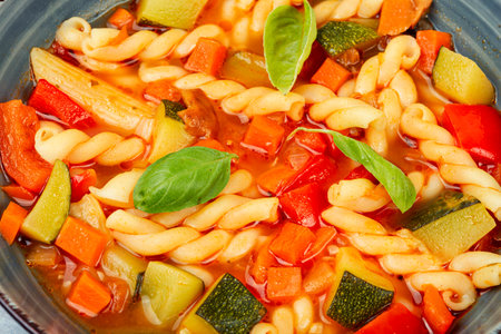 Preparing delicious minestrone soup made from seasonal vegetables and pasta. Close upの写真素材
