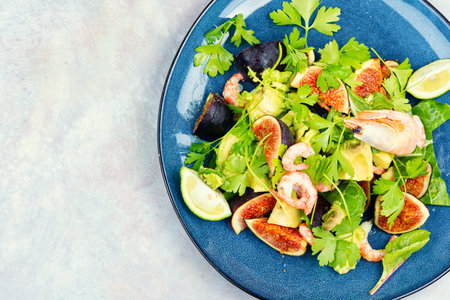 Delicious fresh salad with prawns, figs, avocado and herbs. Copy space.の写真素材