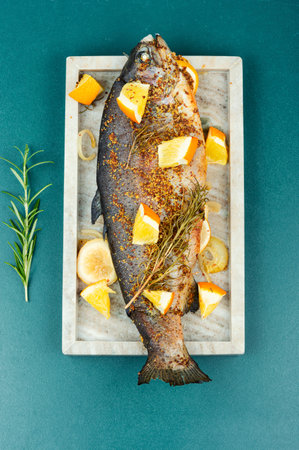 Trout fried with orange and rosemary. Top view.