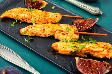 Tasty and colorful chicken meat skewers with figs on a plate. Delicious summer lunch.の写真素材