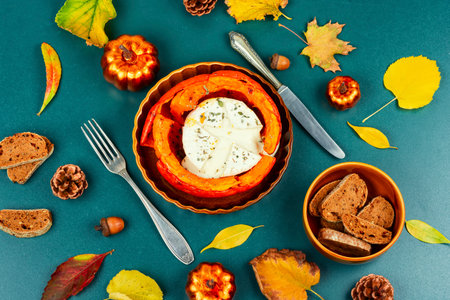 Halved roasted squash filled with spicy and camembert cheese. Flat lay.の写真素材