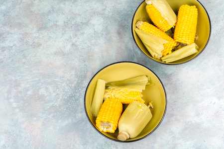 Plate of boiled corn on the cob or maize. Space for text.