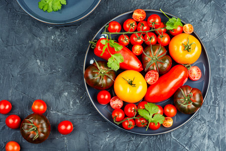 Assortment of ripe tomatoes varieties. Platter of colorful tomatoes and cherry tomatoes.の写真素材