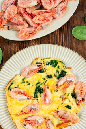 Appetizing egg omelette with shrimps and fresh spinach.