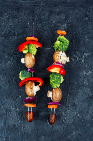 Raw barbecue grilled vegetable kebabs with mushrooms, peppers and broccoli. Top view.の写真素材