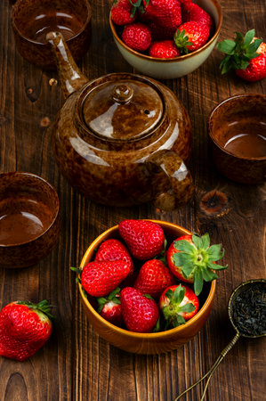 Summer fruit tea with fresh strawberries, health drink on rustic wooden table.の写真素材