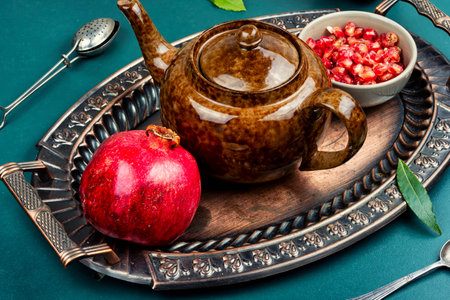 Fruit hot tea with pomegranate, hot drink in a kettle or teapot and tea cup.の写真素材