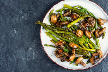 Aromatic dietary dish of fried green asparagus and champignon mushrooms. Gourmet cuisine. Copy space.の写真素材