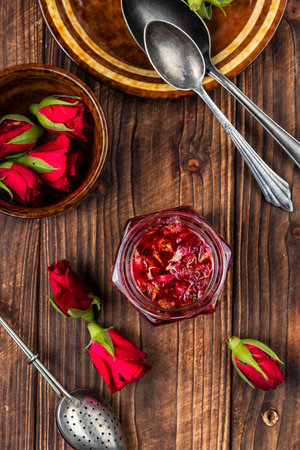 A jar of delicious tea rose jam for tea drinking on rustic wooden table.の写真素材