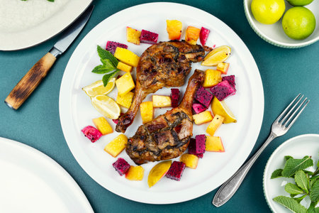 Duck recipes, tasty roasted duck legs with pitaya or dragon fruit and pineapple. Top view.の写真素材