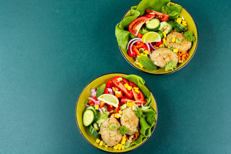 Appetizing Buddha Bowls with Fresh Vegetables and Fish cutlets or fish cakes. Copy space. Space for text.の写真素材