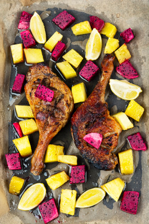 Duck recipes, tasty roasted duck legs with pitaya or dragon fruit and pineapple in baking sheet.の写真素材