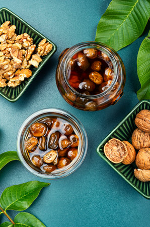 Jam made from green fresh walnuts and peeled walnut. Green fresh walnut dessert.の写真素材