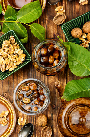 Walnut jam made from green fruits on wooden rustic background. A delicacy made from unripe nuts.の写真素材