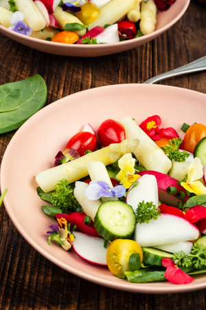 Spring salad, green salad with white asparagus and edible flowers.の写真素材