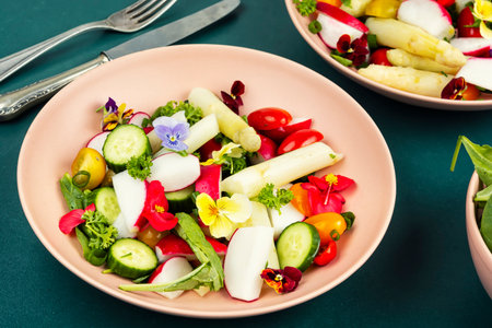 Delicious and healthy vegetarian salad with white asparagus, tomatoes and edible flowers fresh spring greens, recipe, diet meal vegan.の写真素材