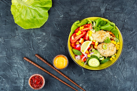 Buddha bowl, healthy and balanced food with vegetables fish cutlets or fish cakes. Space for text.の写真素材