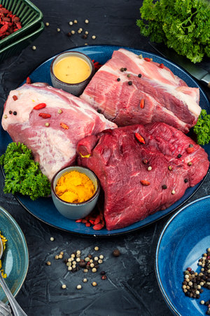 Pieces of raw pork beef meat with ingredients and seasoning.の写真素材