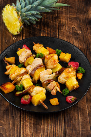 Roasted or grilled chicken kebab with fresh pineapple on wooden rustic backgroundの写真素材