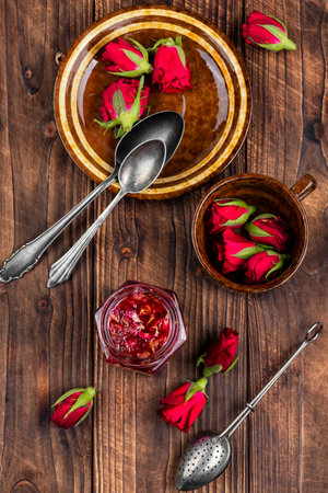 Jar with rose jam and flower on the table, rose petals jam and tea cooking utensils.の写真素材