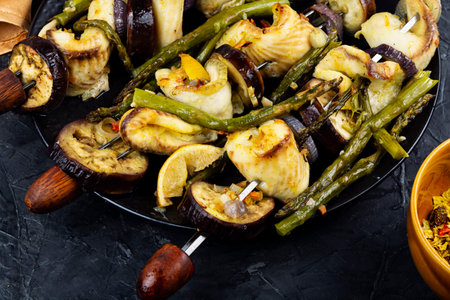 White fish fillet with asparagus and vegetables on skewers. Barbecue seafood.の写真素材