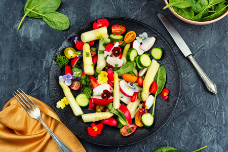 Colorful mix of vegetables and edible flowers in vegan salad bowl. Overhead view.の写真素材