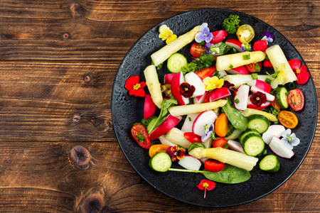 Healthy vegetarian salad with white asparagus, tomatoes and edible flowers fresh spring greens, recipe, diet meal vegan. Space for text.の写真素材