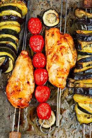 Skewers with baked chicken breast and grilled eggplant in baking sheet, food backgroundの写真素材