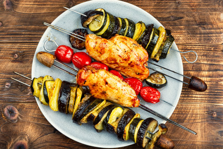 Grilled meat and roasted vegetables or barbecue, chicken breast meat, zucchini and eggplant fried on skewers.の写真素材