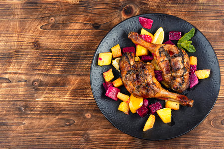 Duck meat cooked with pineapple,lime and dragon fruit, baked duck legs on wooden rustic background. Space for text.の写真素材