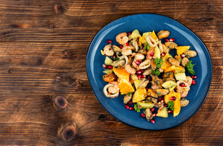 Salad of mixed seafood, orange, kiwi fruit and pomegranate seeds. Delicious and healthy food. Copy space.の写真素材