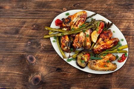 BBQ chicken wings with green asparagus on wooden rustic background. Flat lay with copy space.の写真素材