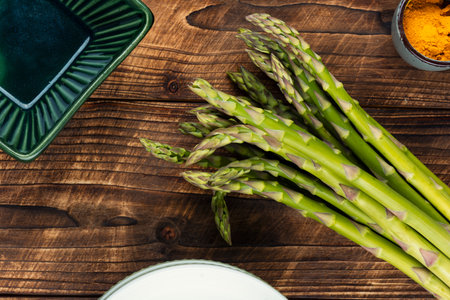 Heap of fresh asparagus on wooden rustic background. Healthy food. Raw, vegan, vegetarian and clean eating.の写真素材